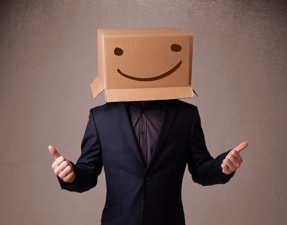 Young man standing and gesturing with a cardboard box on his head with smiley face