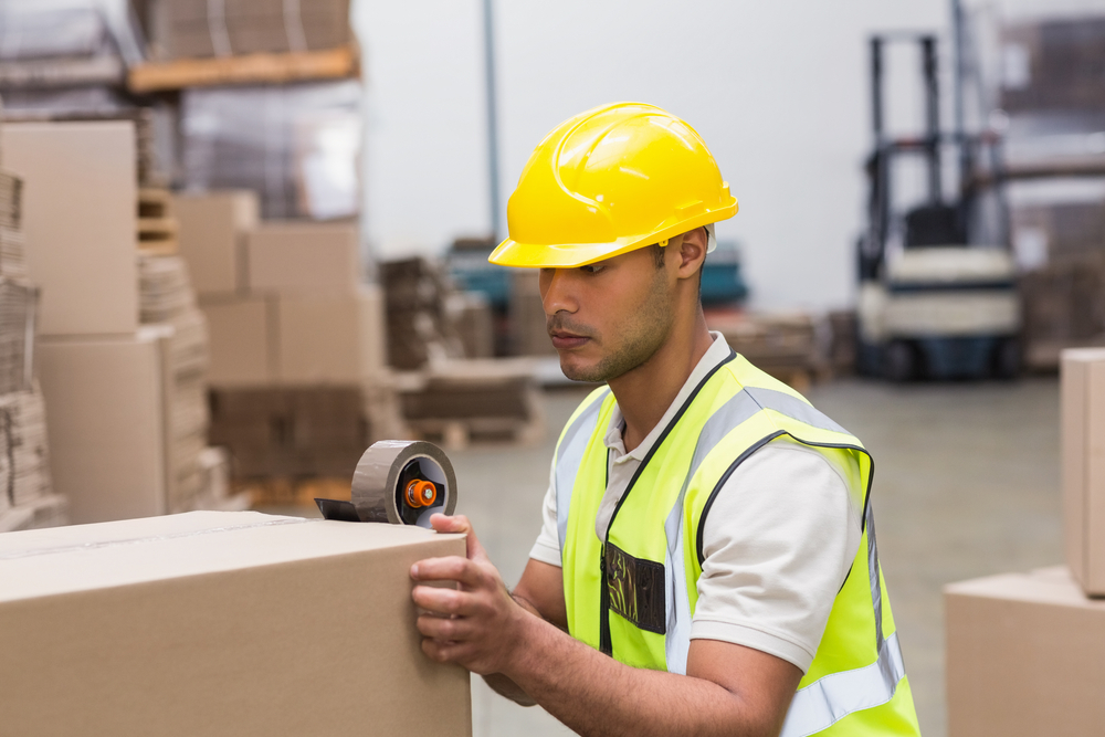 Worker in warehouse preparing goods for dispatch